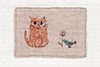 medium sized framed textile picture of a cat and a bird holding a flower